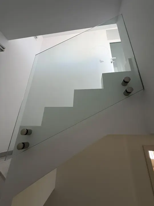 Barandilla de cristal templado con fijaciones de acero inoxidable en escalera