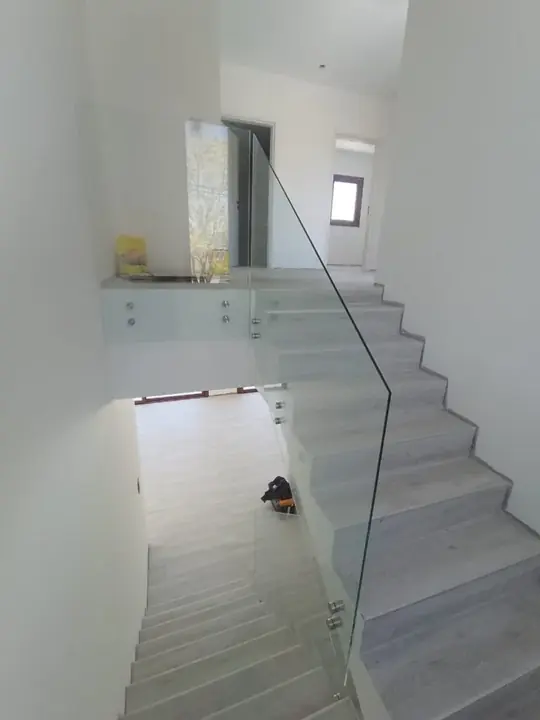 Barandilla de cristal en escalera interior blanca
