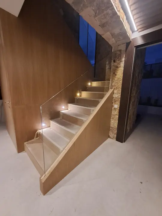 Barandilla de cristal en escalera revestida de madera