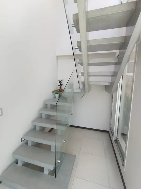 Escalera de peldaños volados con barandilla de cristal templado