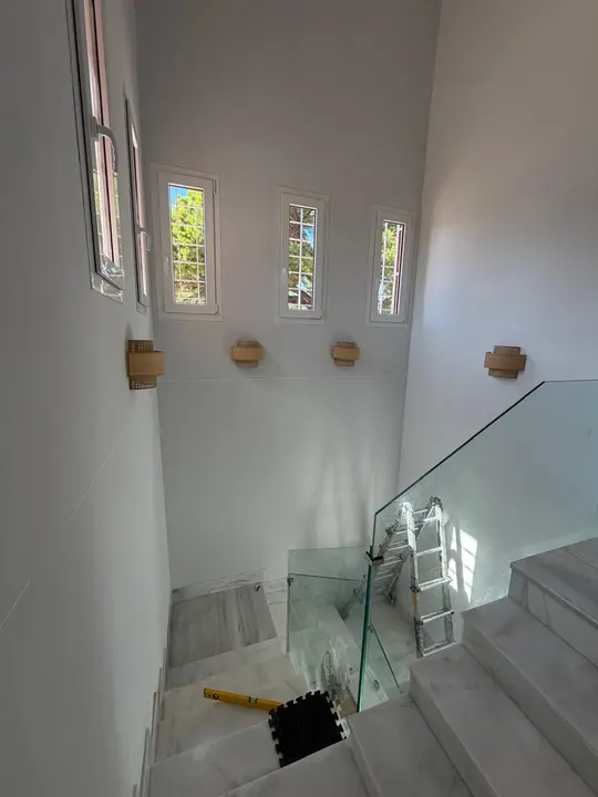 Barandilla de cristal en hueco de escalera con vidrieras