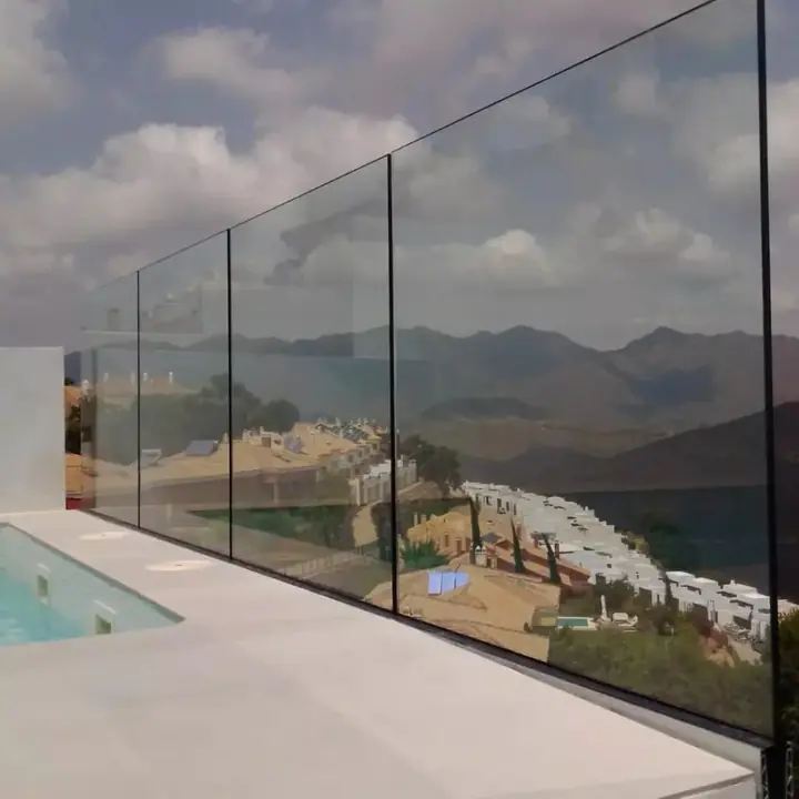 Barandilla de cristal sin perfiles en terraza con piscina y vistas a la sierra