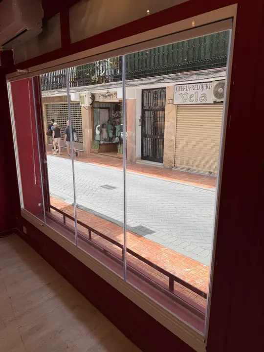 Escaparate con hojas de cristal plegables abierto a la calle