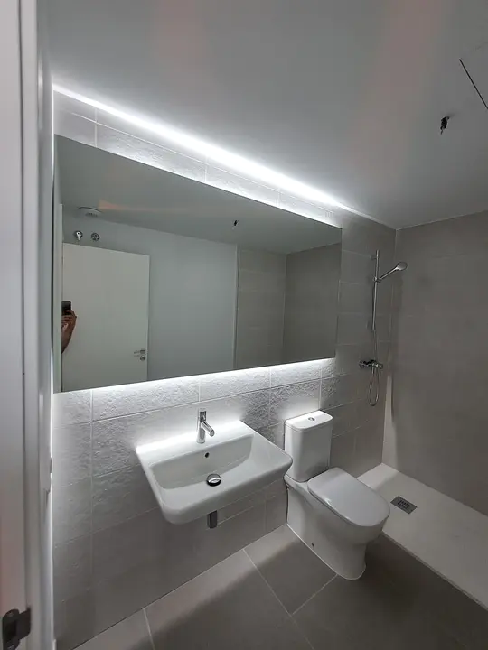 Espejo con iluminación LED en baño blanco