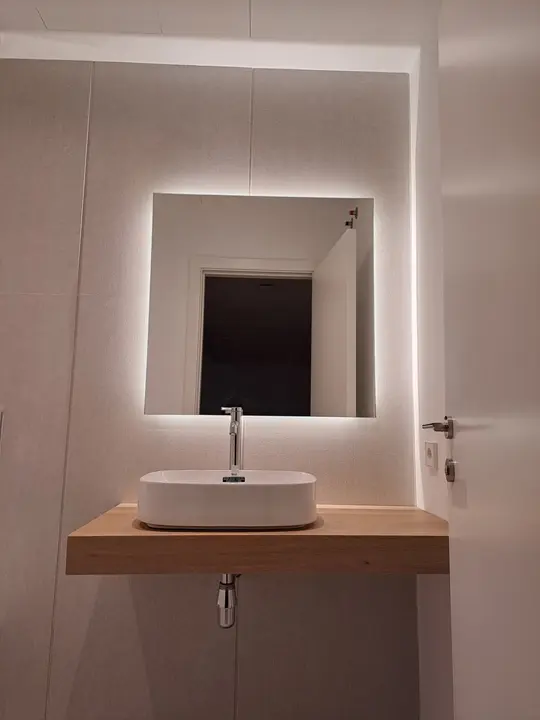 Espejo LED cuadrado sobre lavabo de madera