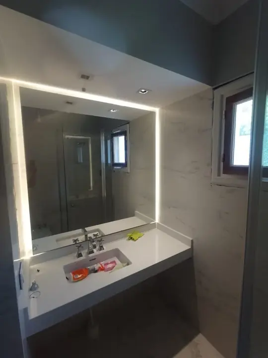 Espejo con iluminación LED sobre lavabo suspendido