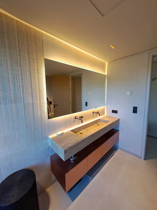 Espejo con LED sobre lavabo de travertino