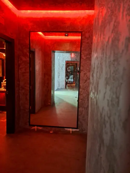 Espejo con perfil LED rojo en pasillo de hostelería