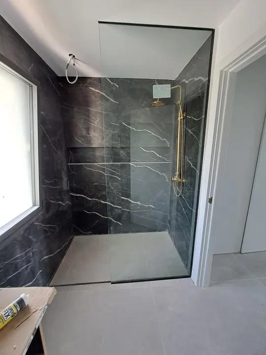 Mampara fija en ducha de mármol negro