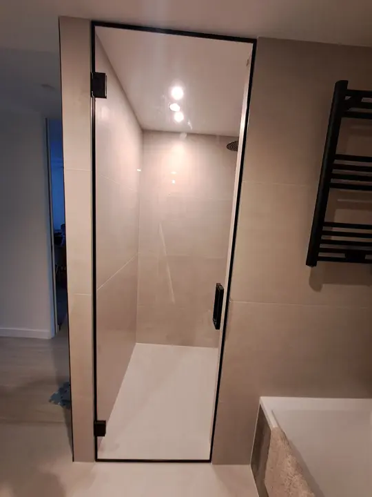 Puerta de ducha de cristal con perfil negro
