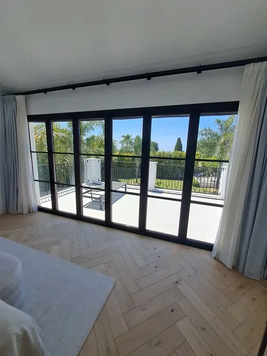 Ventanales de cristal con perfil negro en dormitorio